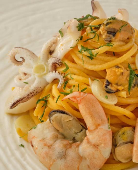 Spaghetti ai frutti di mare con gamberi, calamari, cozze e prezzemolo.