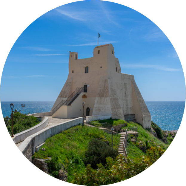 Edifici affacciati sul mare con cielo limpido e onde leggere.