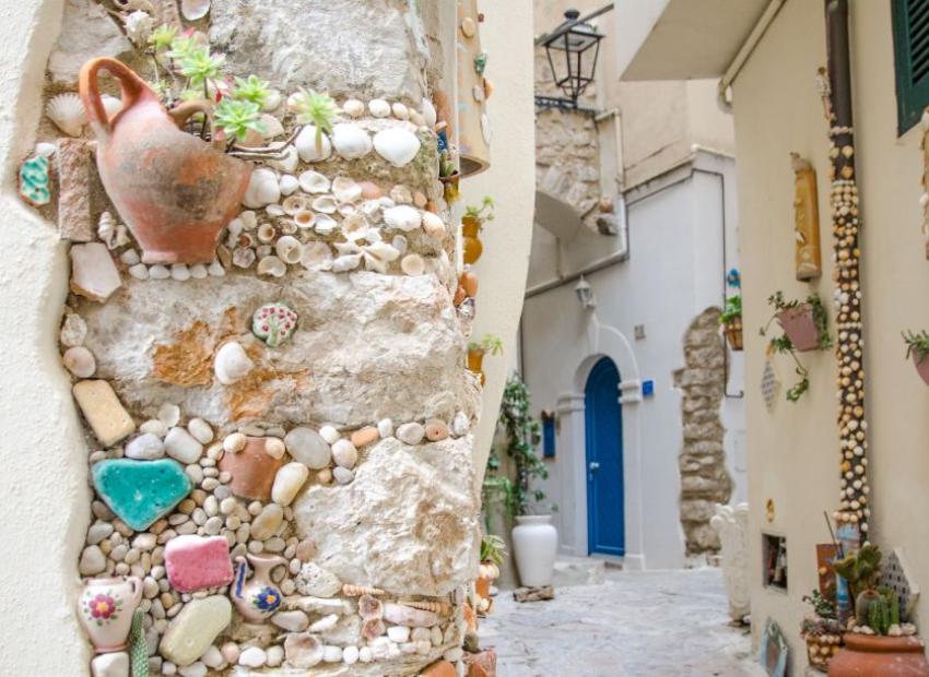Vicoli decorati con conchiglie e ceramiche colorate, atmosfera pittoresca e artistica.