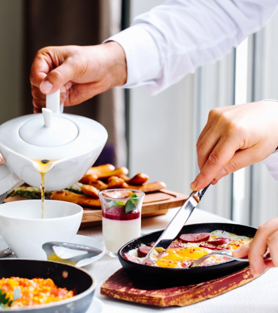 Colazione con tè, uova al tegamino e dessert alla frutta.