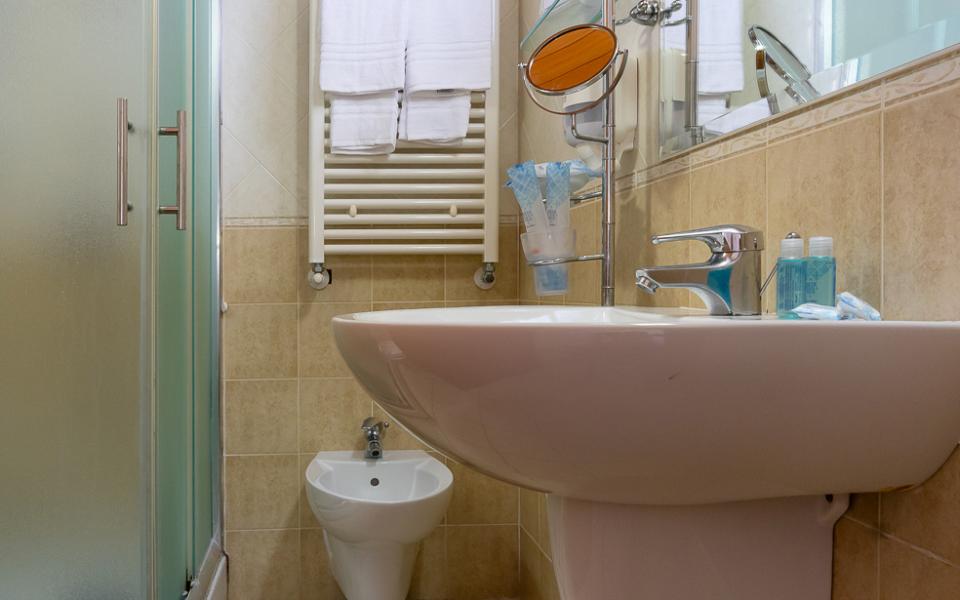 Bagno accogliente con doccia, bidet e lavabo; atmosfera calda e ordinata.